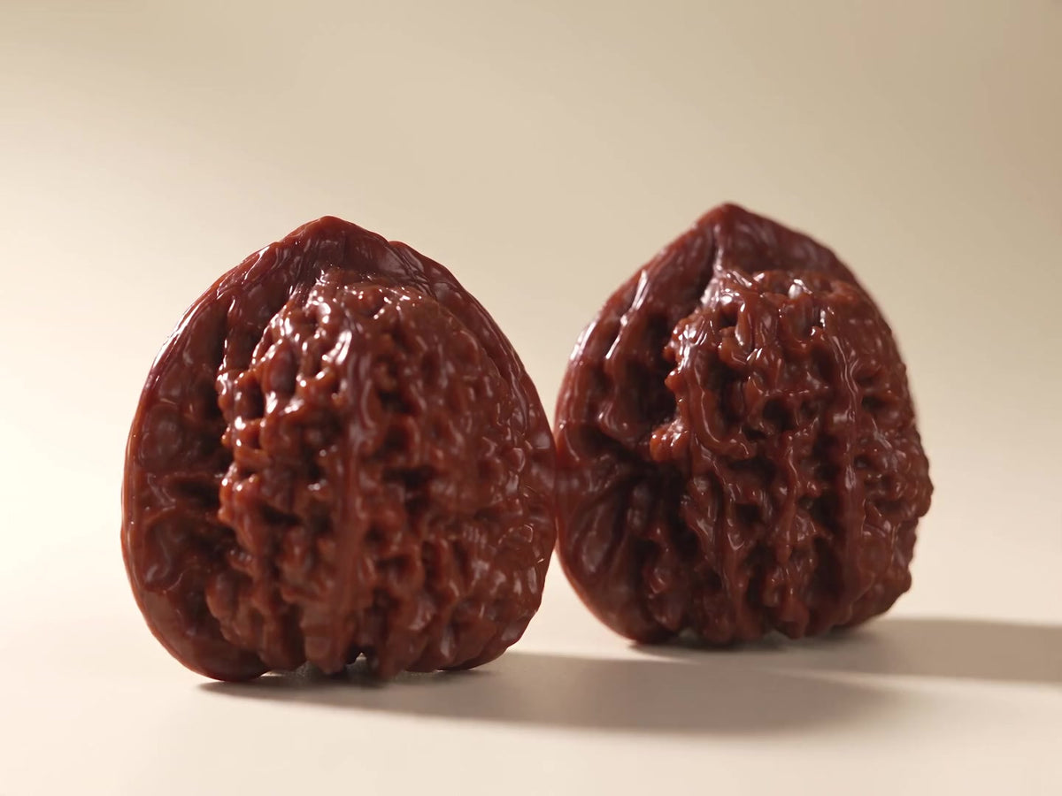 A slow studio view of a patinated Wenwan walnut pair.